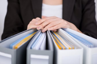 Midsection of businesswoman with binders at office.jpeg